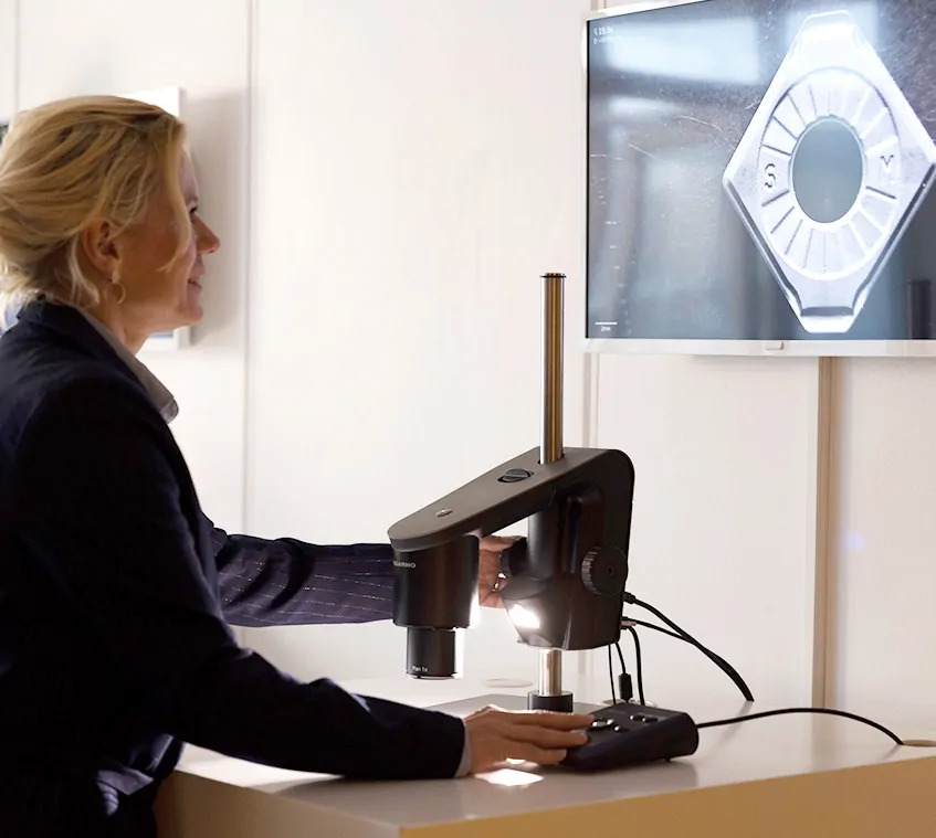 Operator inspecting metal parts with a TAGARNO digital microscope
