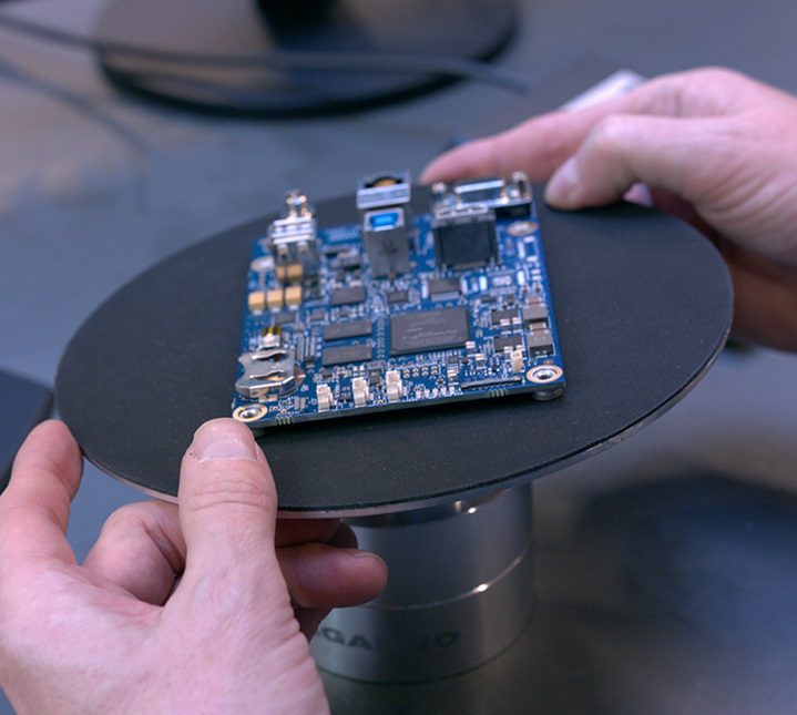 Operator using tilting table and digital microscope to inspect printed circuit board
