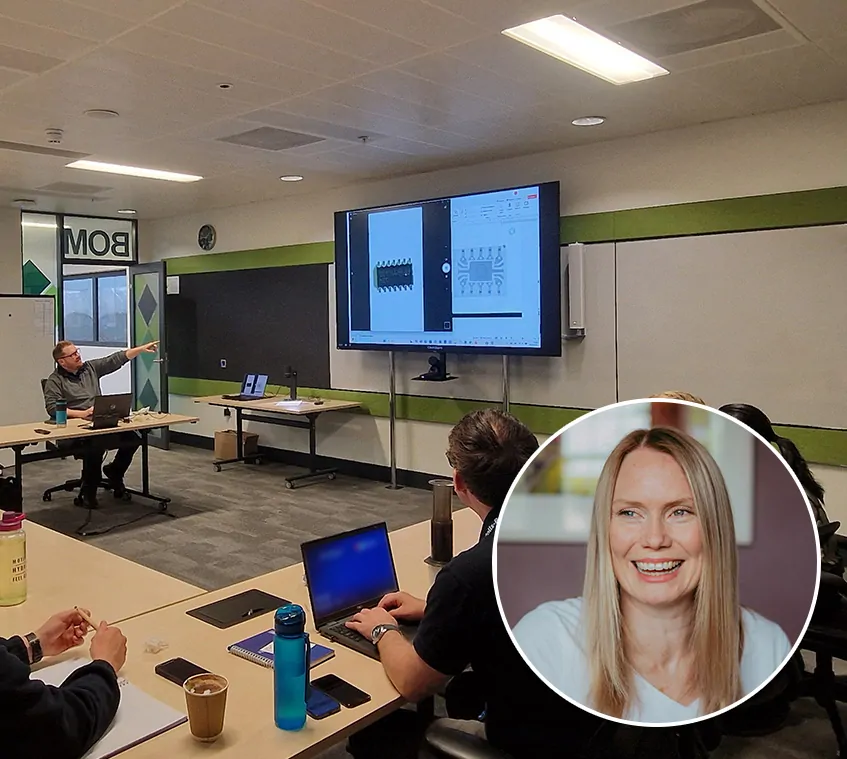 Class room location with electronic failure analysis professionals looking at a projector with live image from TAGARNO ZIP digital microscope and portrait photo of Suzanne Costello